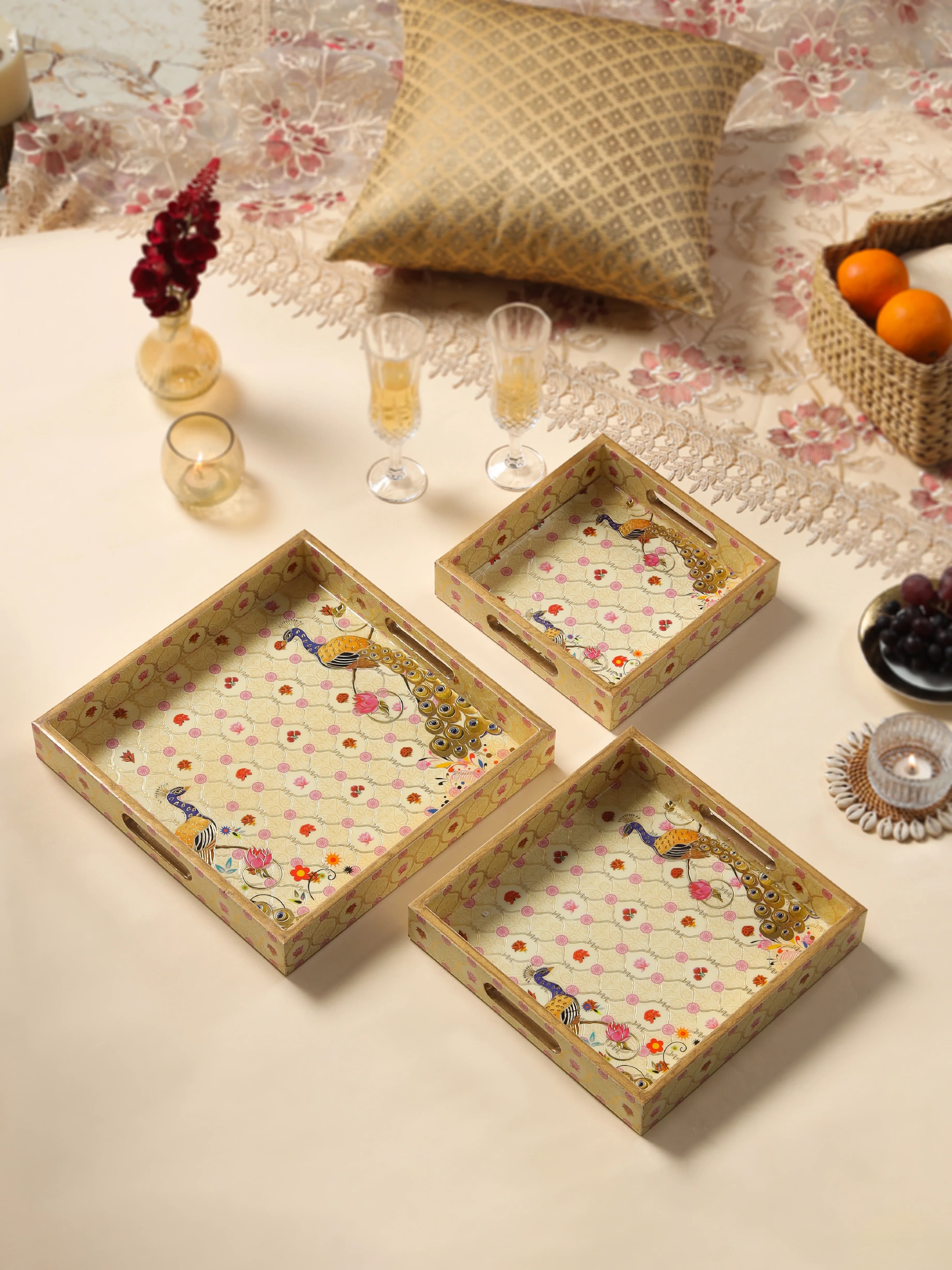 LuxeHome Mayura peacock tray set — three handcrafted trays with Mughal peacock motifs styled on a festive table